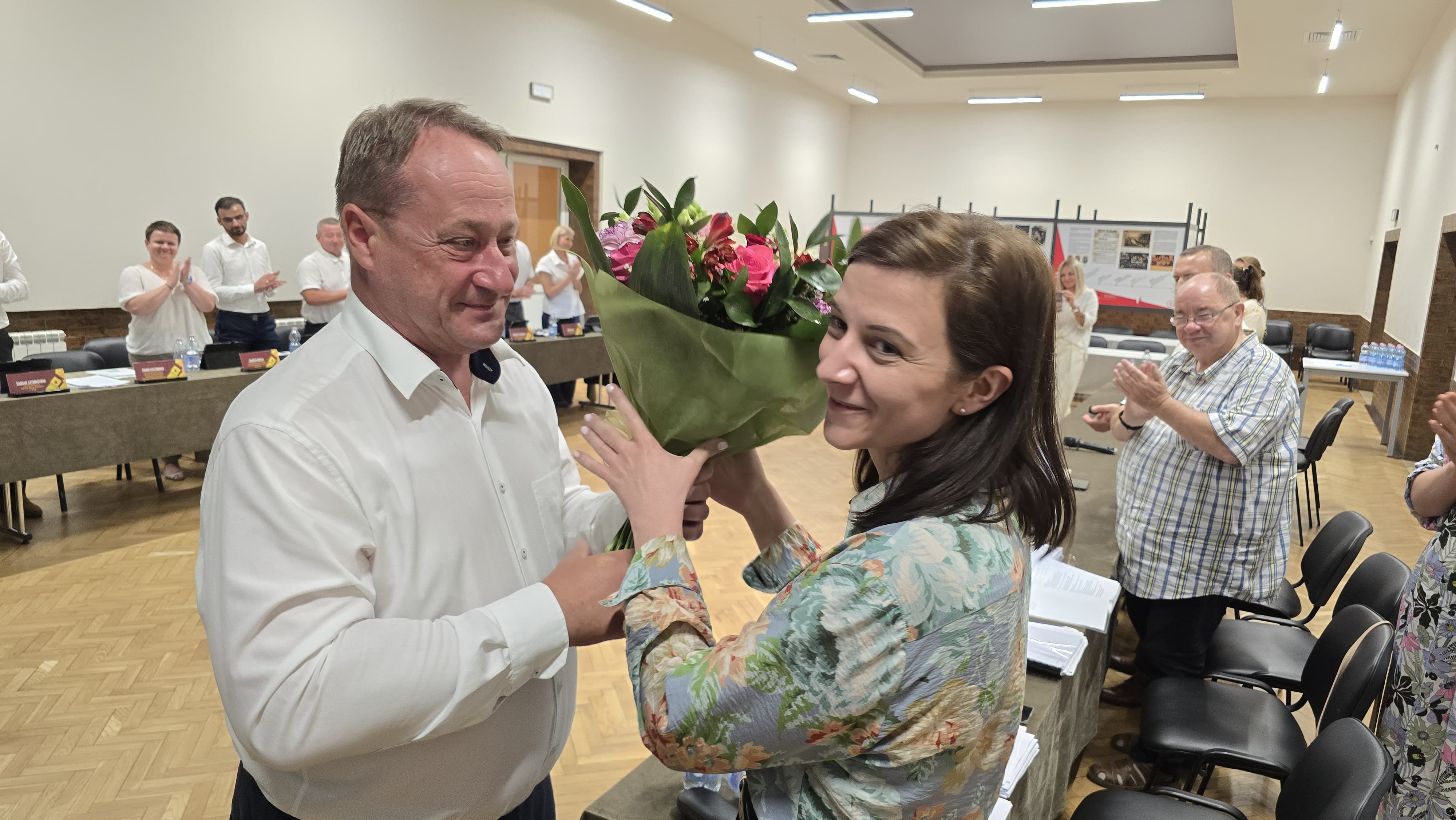 Burmistrz wręczający kwiaty pani Skarbnik.